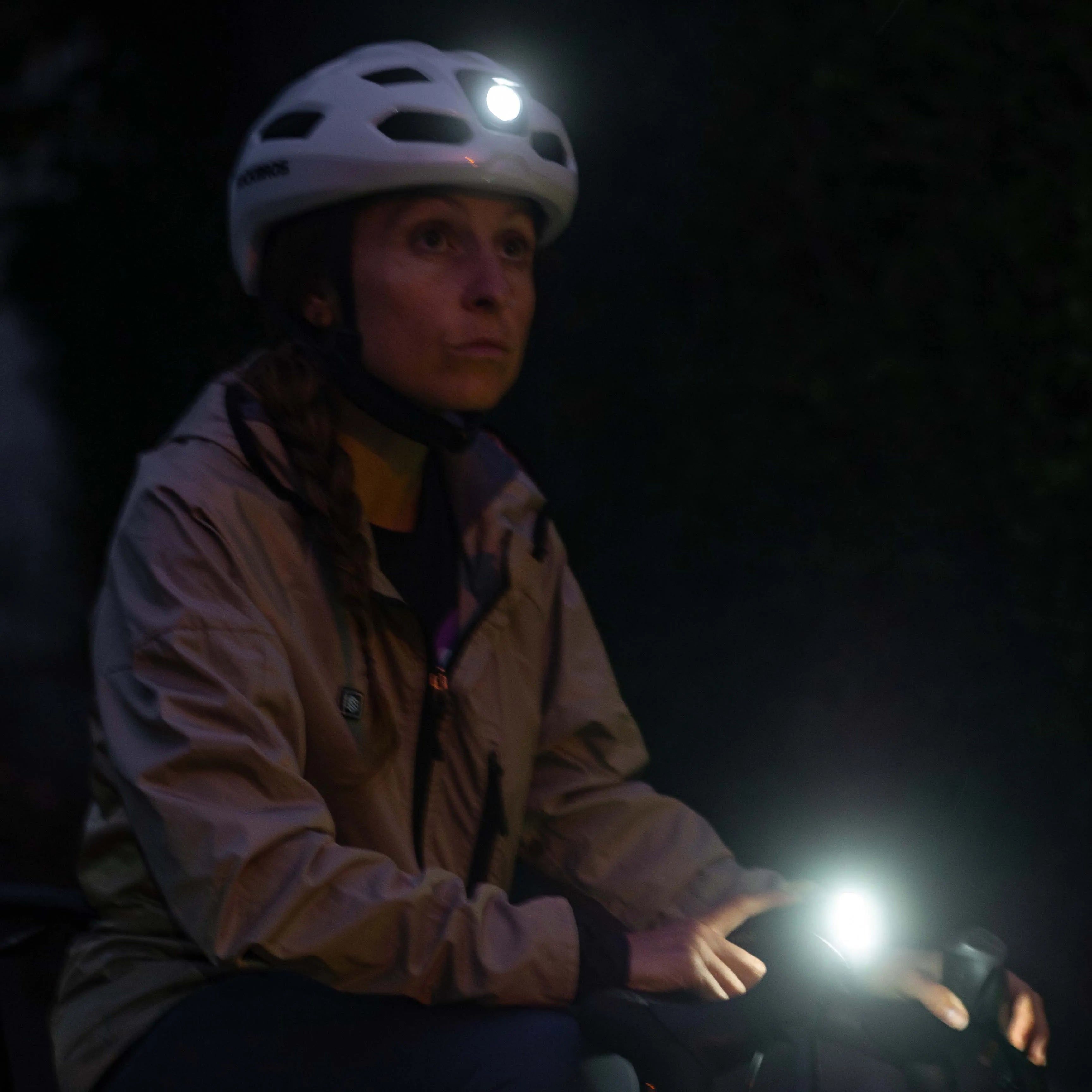 Cyclist using helmet with light for visibility in traffic, moving headlight direction, safer intersections, and backup lighting at night