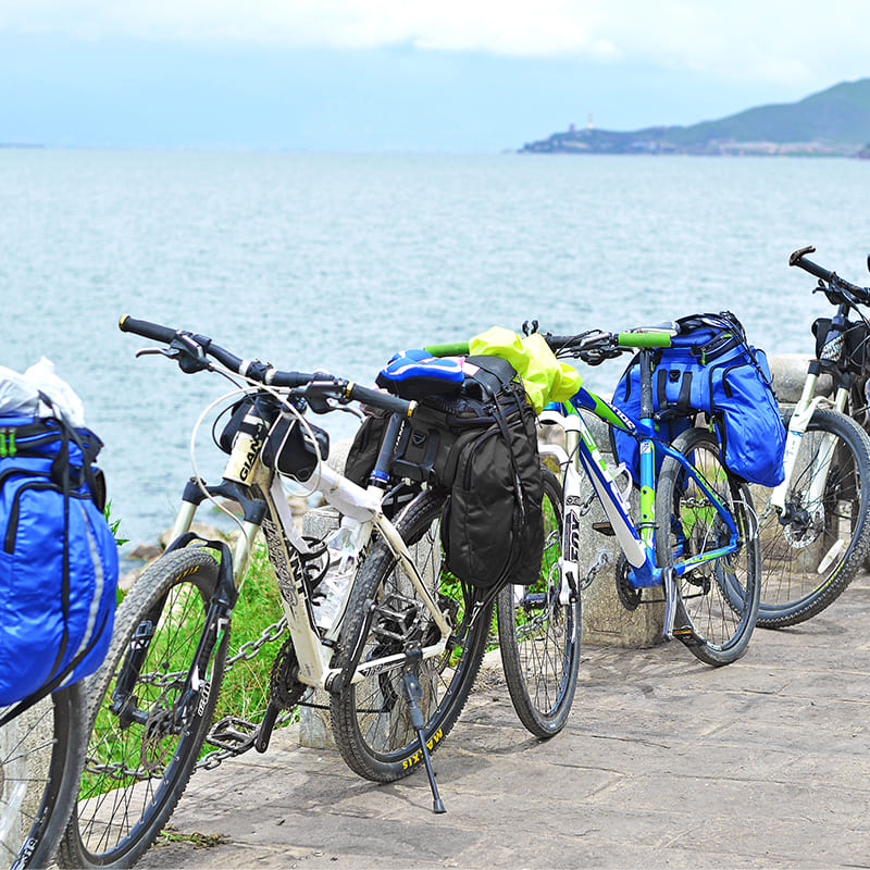 Mountain Bikes Equipped with Pannier Bags Parked by the Coast for Scenic Long-Distance Cycling Adventures