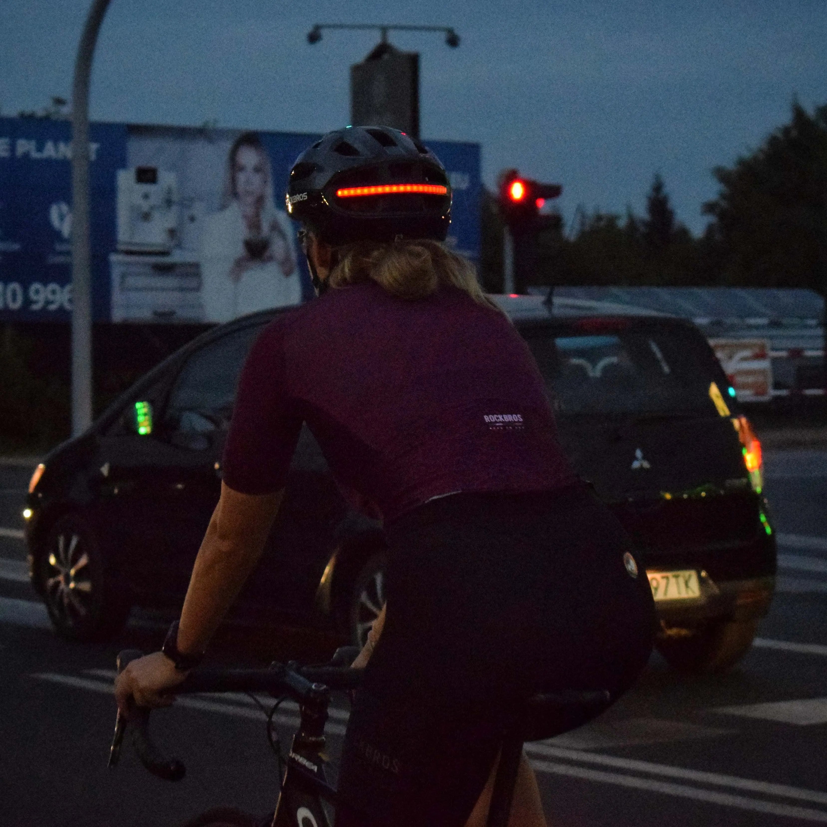 Cyclist using helmet with light for visibility in traffic, moving headlight direction, safer intersections, and backup lighting at night