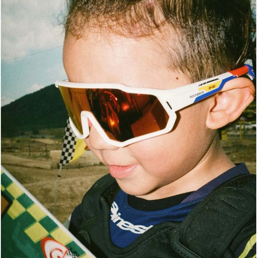 Little cyclist wearing SP383 kids polarized cycling sunglasses for outdoor sports, UV protection eyewear for children.