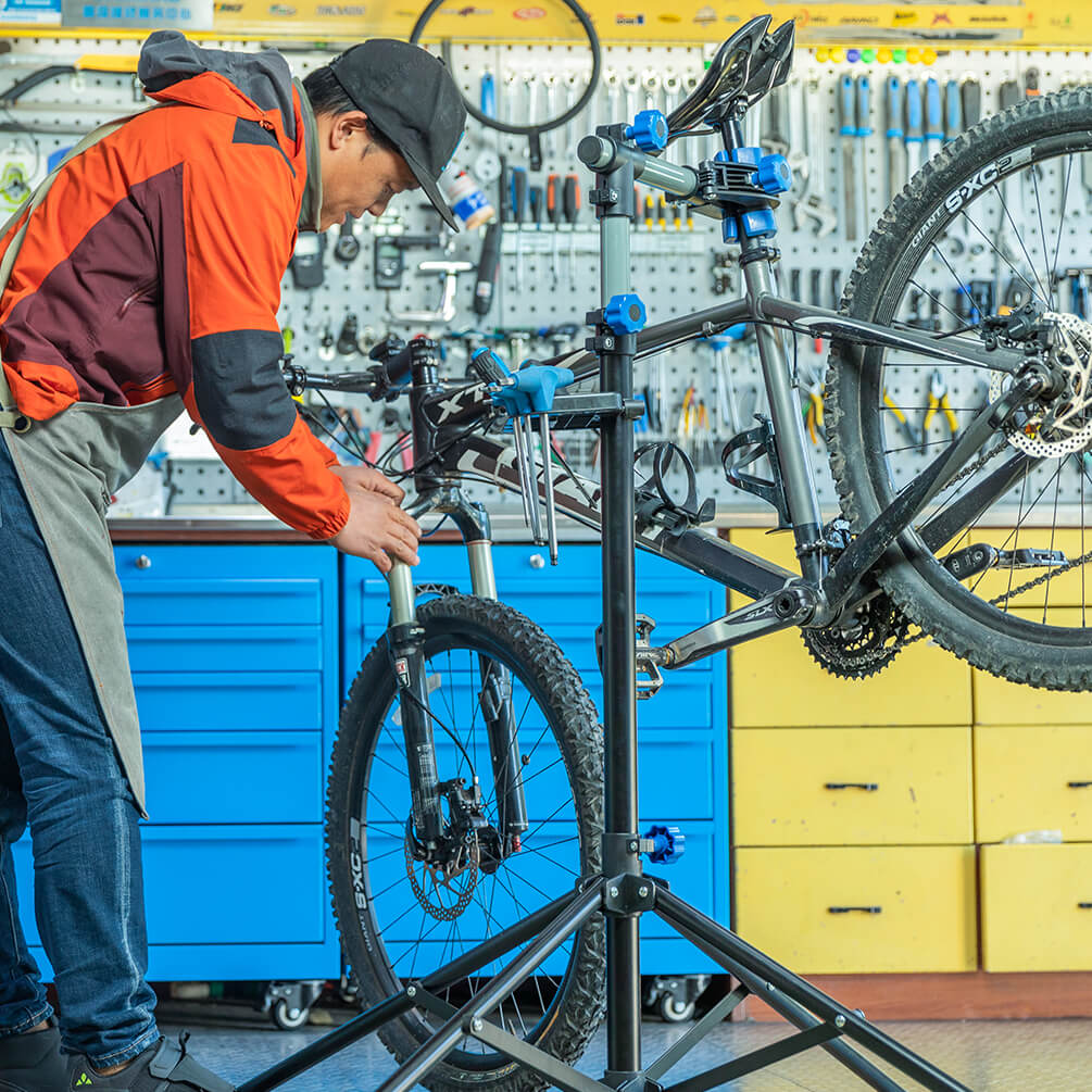 ROCKBROS adjustable telescopic bike repair stand with 360-degree rotating clamp, height adjustment, and foldable four-leg base for bicycle maintenance