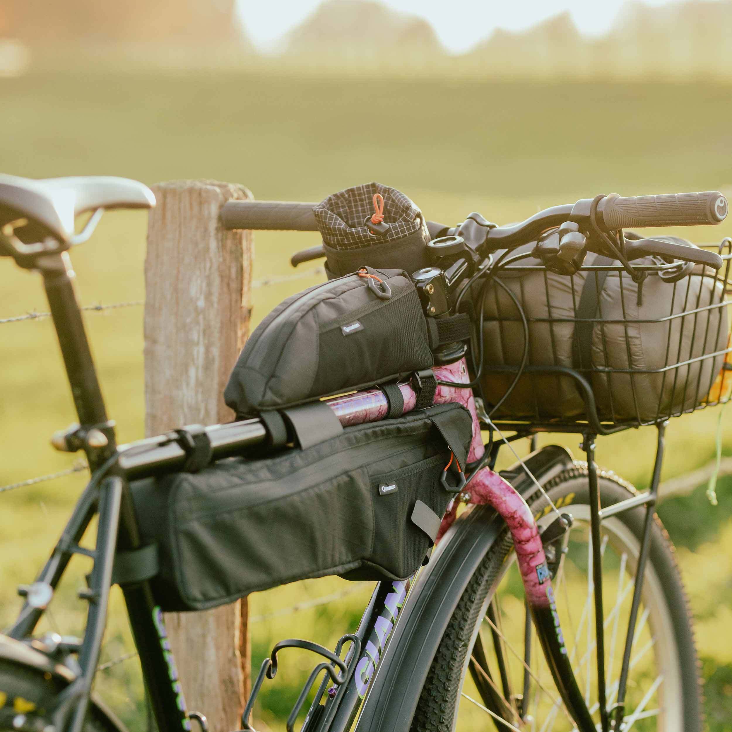 Slim profile bikepacking frame bag installed on a gravel bike down tube, designed to prevent knee rub during long rides.